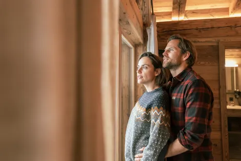 Paar sieht aus dem Fenster in der Schönwieshütte